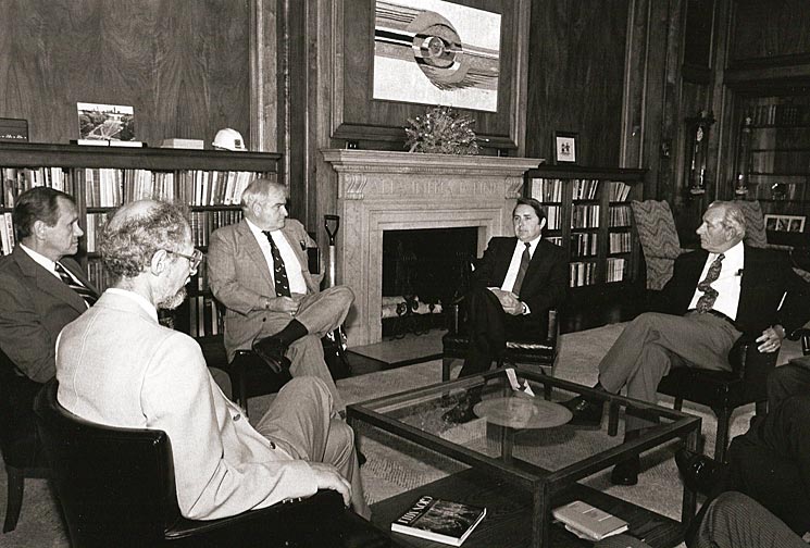 5 people seated around coffee table in 